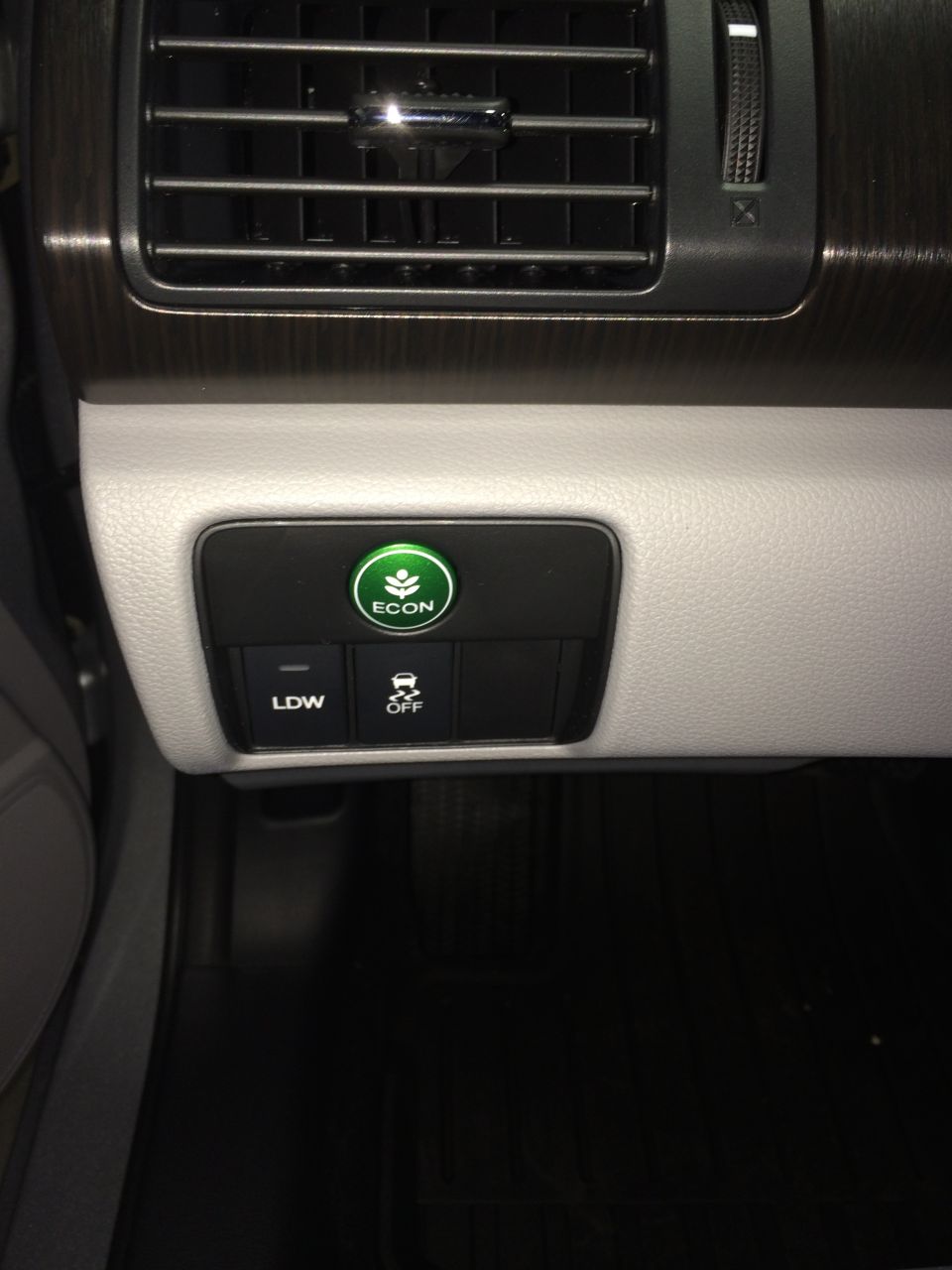 Dashboard with ECON button, LDW button, and traction control off button. The air vents are above the controls