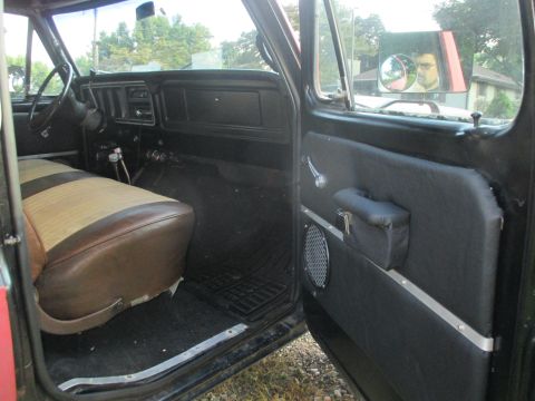 1979 Ford Bronco - The interior of a vintage SUV is visible, two-tone seats and a dark dashboard.