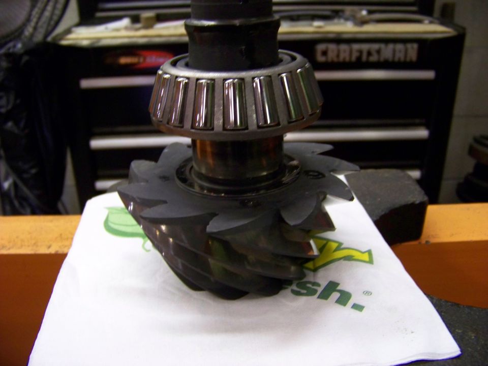 Differential gear and bearing on a white paper with green logo, in front of a Craftsman toolbox