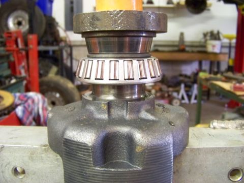 1999 Mercury Grand Marquis - A differential bearing assembly is shown in a vise, with tools and vehicle parts in the background.