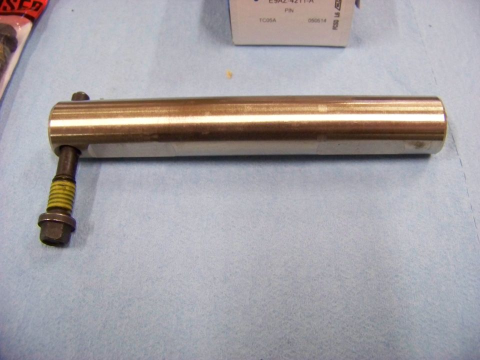 Metal shaft with a bolt attached, resting on a blue cloth