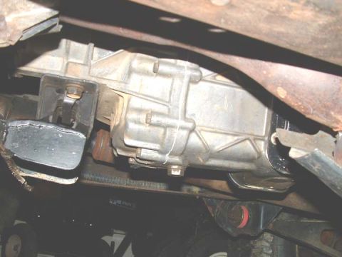 1994 Ford Bronco - Close-up of the vehicle's transmission and exhaust components, showing a worn rubber mount.