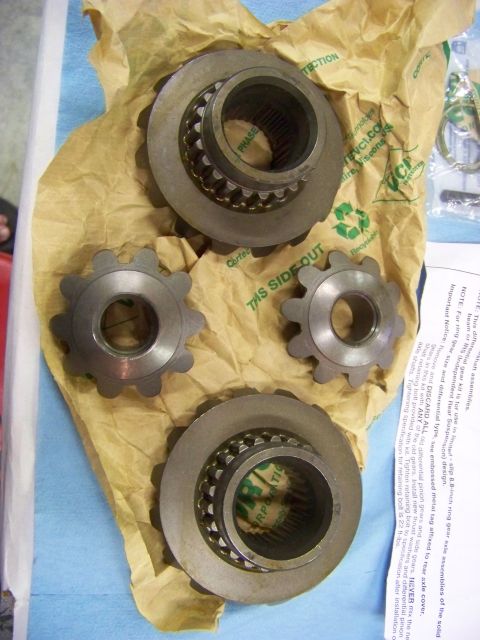 1999 Mercury Grand Marquis - Differential gears and pinions are laid out on brown paper packaging, with a document visible to the right.