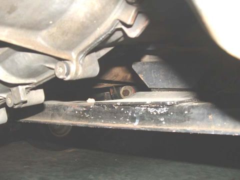 1994 Ford Bronco - The underside of a vehicle shows mechanical components and some handwritten markings on a bracket.