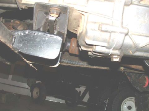 1994 Ford Bronco - A close-up view of a vehicle's undercarriage, focusing on the transmission and driveshaft components.