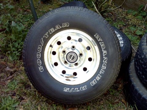 1995 Ford Bronco - A single tire and wheel assembly is shown resting on grass.