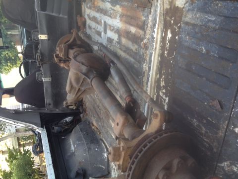 1994 Ford Bronco - Close-up of a Dana 60 axle assembly, likely for a 4x4 conversion, resting in a vehicle's cargo area.