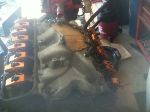 1978 Ford Bronco - Close-up view of an engine block bright orange valve covers and rocker arms, likely undergoing maintenance or repair.
