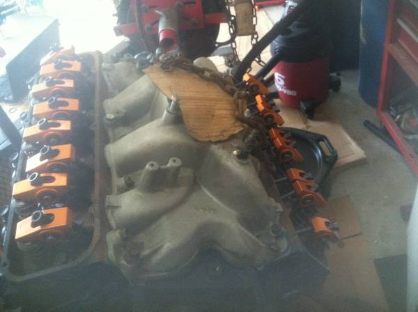 Engine block with orange valve covers and rocker arms, viewed from the side
