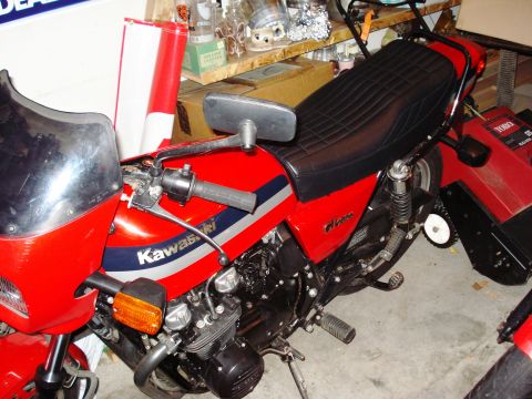 2008 Ford Crown Victoria - A red Kawasaki motorcycle is parked indoors, showing its side profile with a black seat and windshield.