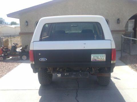 1988 Ford Bronco - Rear view of a white and black Ford Bronco with a license plate visible.