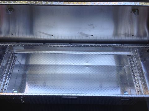 1992 Ford F-150 - Interior view of an open aluminum truck bed toolbox, showing storage compartments.