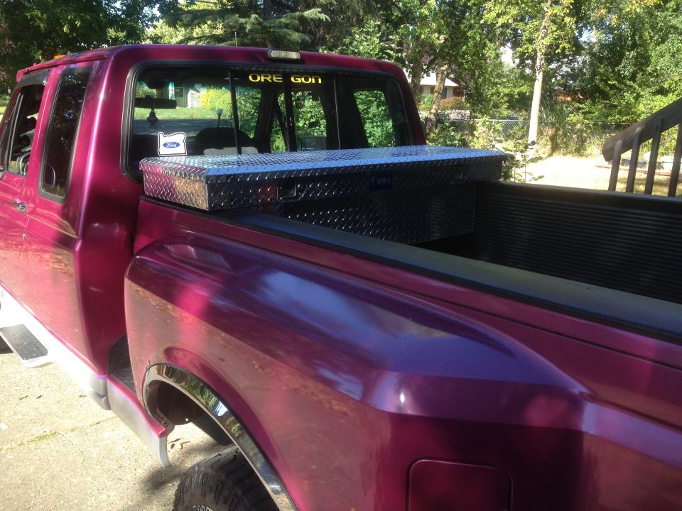 Side view of a 1992 Ford F-150 pickup truck with a diamond plate toolbox in the bed