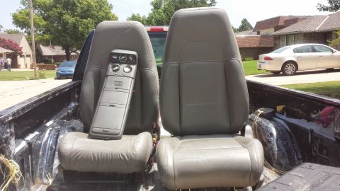 1990 Ford Bronco - Interior vehicle parts, including seats and a console, are loaded in the bed of a pickup truck.