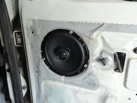 1990 Ford Bronco - Close-up of a car door panel showing a speaker installation.