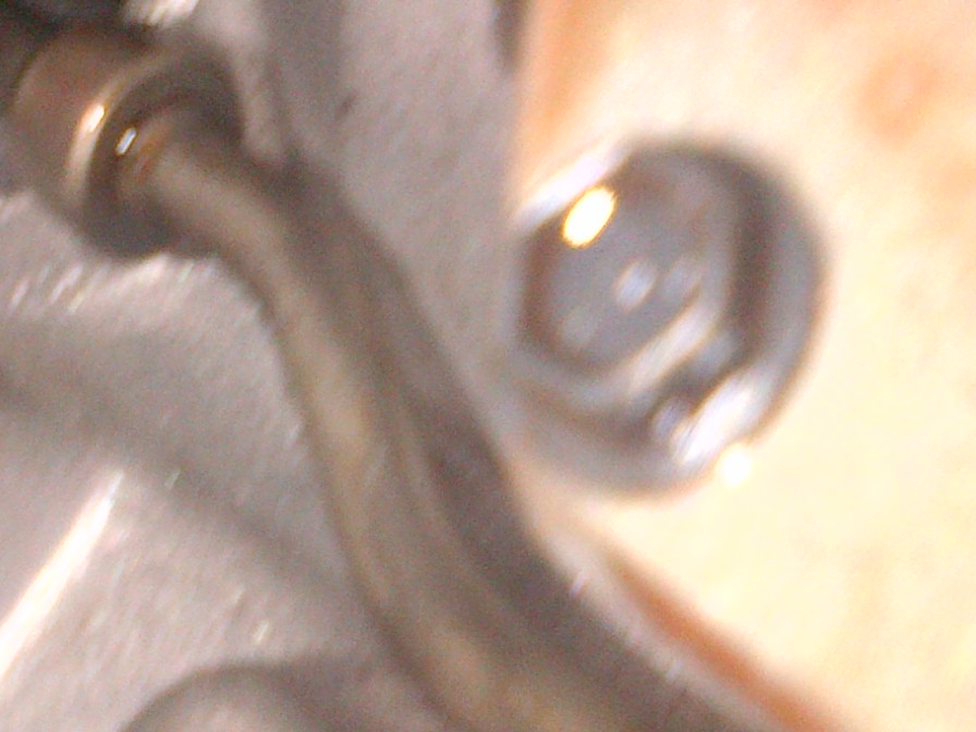 Close-up of a metallic transmission component with a bolt head visible