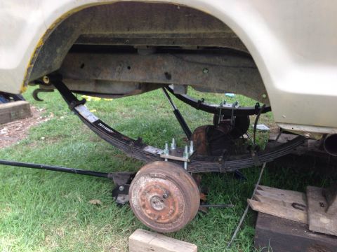 1979 Ford Bronco - Close-up view of the rear suspension system of a vehicle, showing leaf springs and the axle.