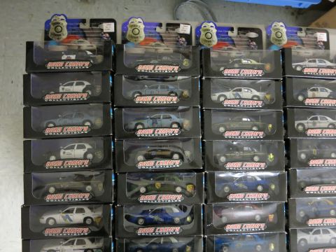 1991 Ford LTD Crown Victoria - A display of various police car model toys, each packaged in its own box.