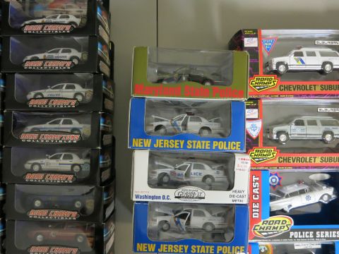 1991 Ford LTD Crown Victoria - A collection of model police cars from various agencies are displayed in their original packaging.