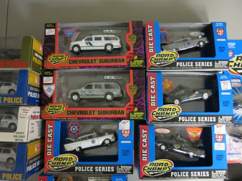 1991 Ford LTD Crown Victoria - A variety of Road Champs die-cast police car models are displayed in their original packaging.