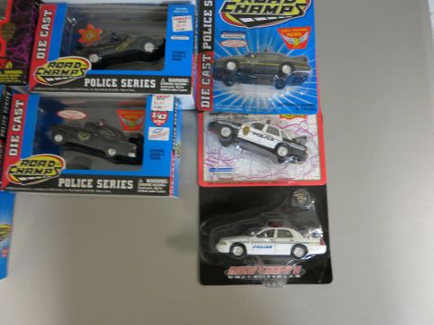1991 Ford LTD Crown Victoria - A collection of die-cast police car models in their original packaging are shown.