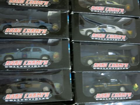 1991 Ford LTD Crown Victoria - A collection of model police cars are displayed in their packaging, with visible branding on each box.