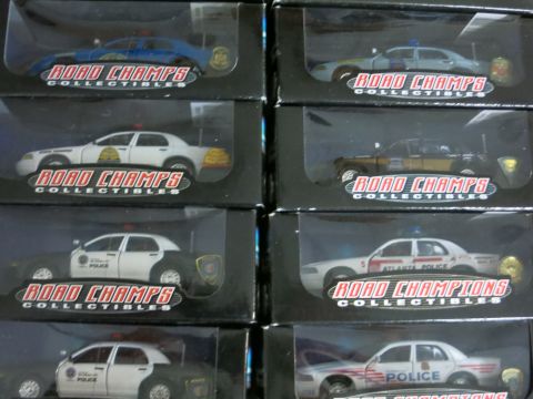 1991 Ford LTD Crown Victoria - A collection of model police cars in their packaging is shown, various police department liveries.