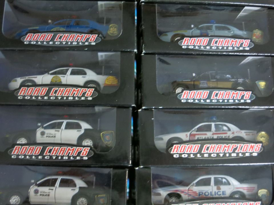 Several boxed model police cars from Road Champs Collectibles are displayed