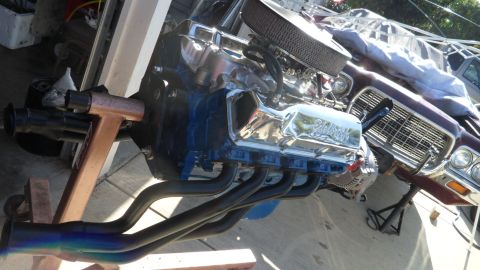 1972 Ford Ranchero - A chrome-accented V8 engine is displayed on a stand, with exhaust headers connected.