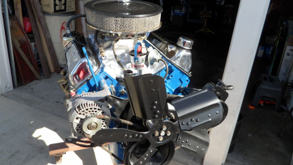 Engine with blue block, chrome valve covers, and air cleaner, angled from the front