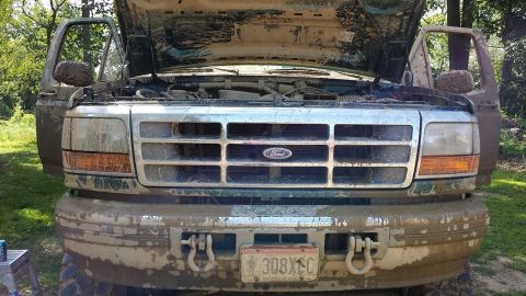 1996 Ford Bronco - Muddy 1996 Ford Bronco with hood and doors open, parked outdoors.