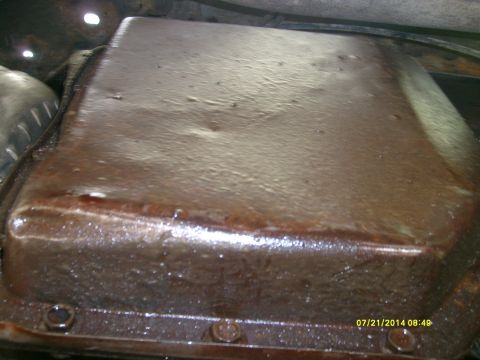 1979 GMC C/K Pickup - Close-up view of a vehicle's oil pan, covered in grime and showing signs of wear.