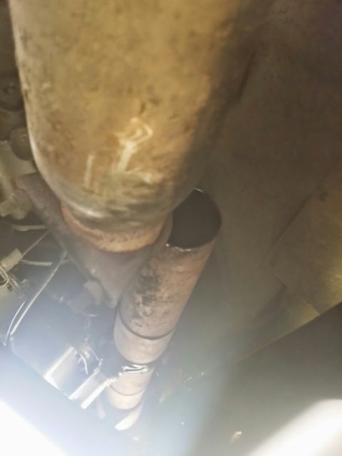 1996 Ford Bronco - Underside view of a vehicle's exhaust system, showing a section of pipe with markings.
