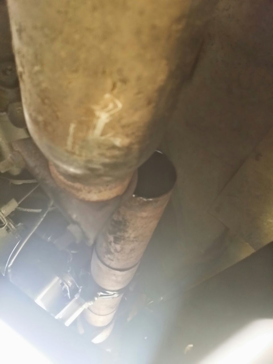 Exhaust pipe with white markings and a clamp, viewed from below
