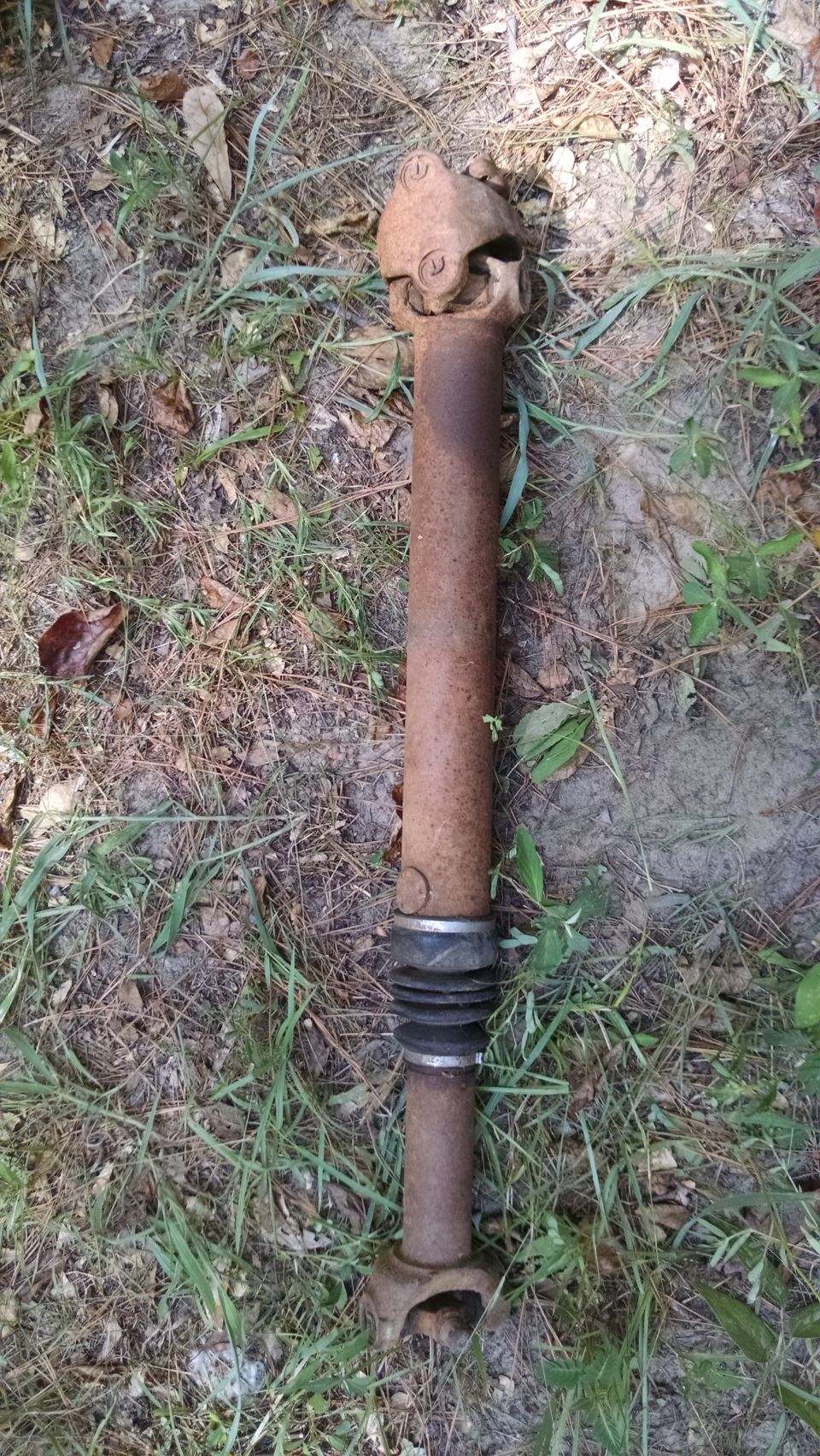 Rusty driveshaft with universal joints and a rubber boot