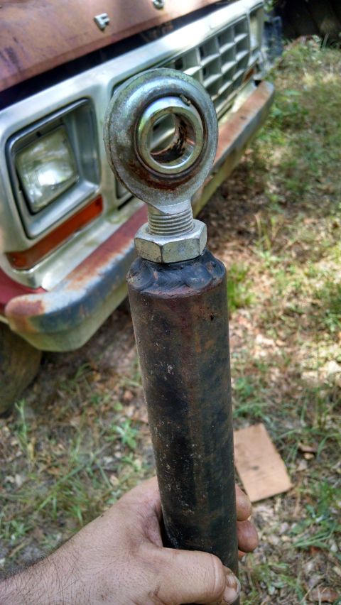 1978 Ford Bronco - A close-up of a tie rod end with the front grille of a 1978 Ford Bronco visible in the background.