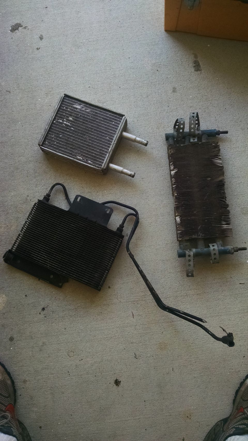 Three car radiators or heat exchangers on a concrete floor