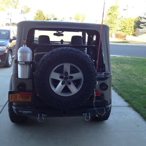 2005 Jeep Wrangler - Rear view of a 2005 Jeep Wrangler showing spare tire, external tank, and license plate.