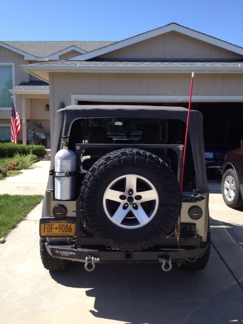 2005 Jeep Wrangler - The rear of a Jeep Wrangler is shown parked in a driveway with a garage in the background.