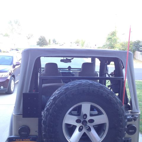 2005 Jeep Wrangler - Rear view of a 2005 Jeep Wrangler showing its spare tire mounted on the back and a soft top.
