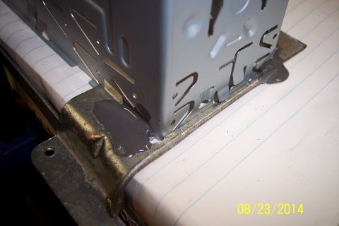 1978 Ford Bronco - Close-up view of a radio plate mounting bracket secured with adhesive to a lined surface.