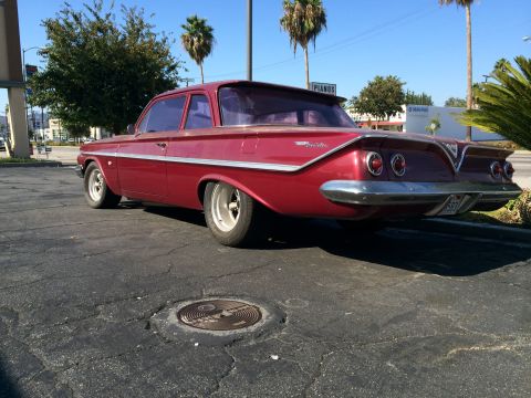 1968 Ford Mustang - This red 1961 Chevrolet sedan features a distinctive rear spoiler and dual taillights, its classic design.