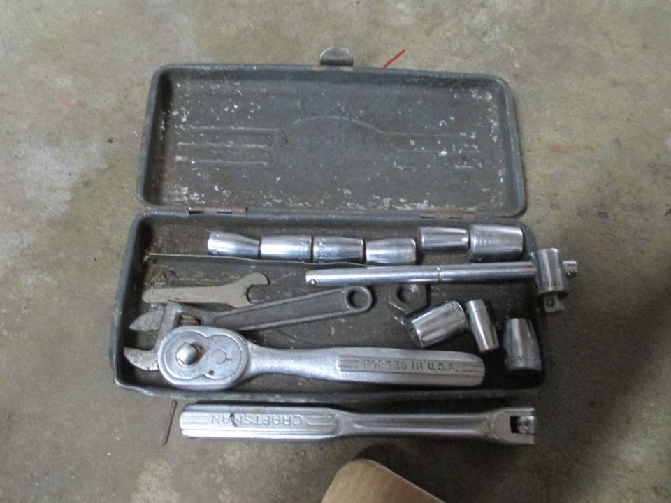 Metal tool case with socket wrench, extension, and sockets. Text reads "CRAFTSMAN"
