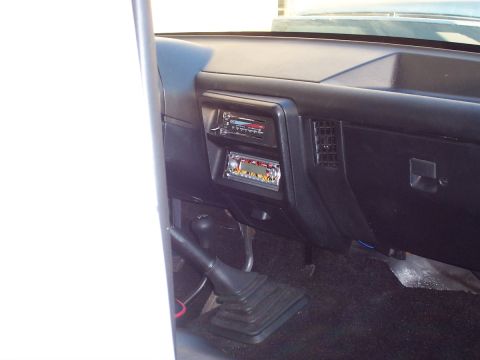 1990 Ford Bronco - Interior view of a 1990 Ford Bronco, a dashboard with two radios and a manual transmission shifter.
