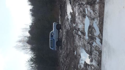 1979 Ford Bronco - This SUV navigates a challenging muddy path, with puddles reflecting the overcast sky.