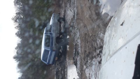 1979 Ford Bronco - A 1979 Ford Bronco navigates a challenging muddy trail, showing its off-road capabilities.