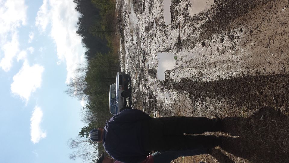 1979 Ford Bronco and another truck stuck in mud on a trail
