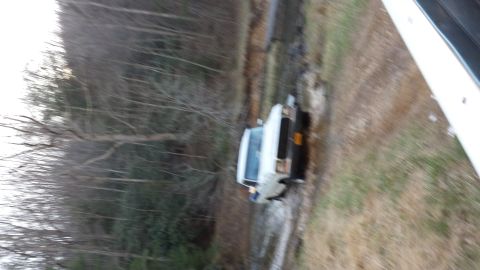 1979 Ford Bronco - This 1979 Ford Bronco is stuck in the mud on a dirt road, surrounded by trees.