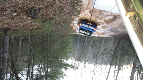 1979 Ford Bronco - A blue 1979 Ford Bronco is being winched out of a muddy trail.