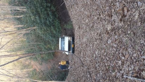 1979 Ford Bronco - White 1979 Ford Bronco parked on a wooded trail covered in fallen leaves.